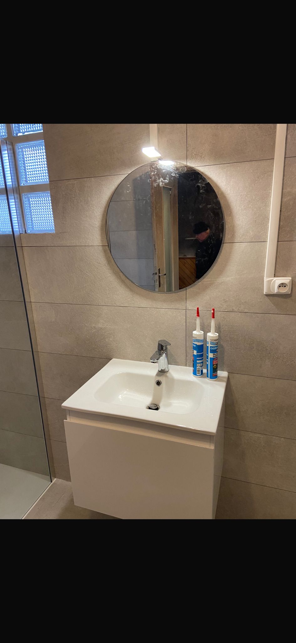 Miroir rond et lavabo suspendu